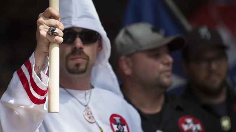 États-Unis. Il porte une cagoule du Ku Klux Klan en guise de masque de protection 