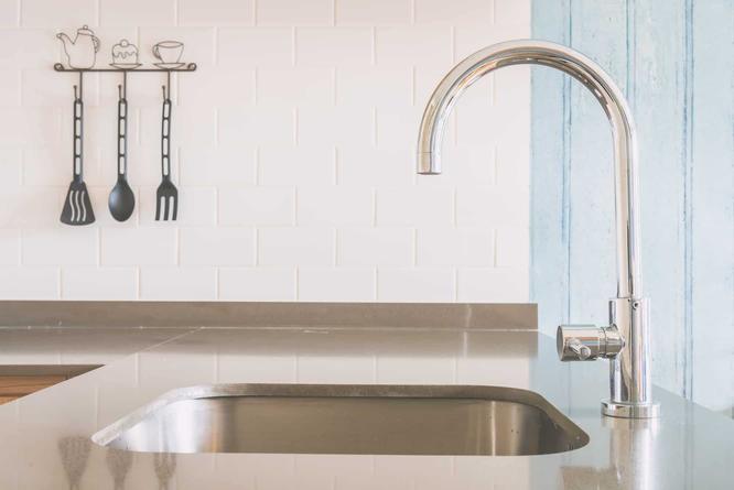 Installing a kitchen faucet to fit the available sink holes 