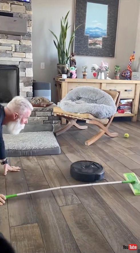  自宅でカーリング気分を満喫するおじいちゃんが楽しそう　ルンバの進行方向を全力で床磨き 