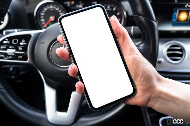 Is it illegal to operate a smartphone while driving or watch a video if the stand is fixed?